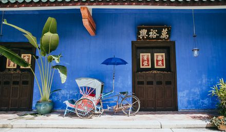 rikscha vor blauer hauswand in penang malaysia
